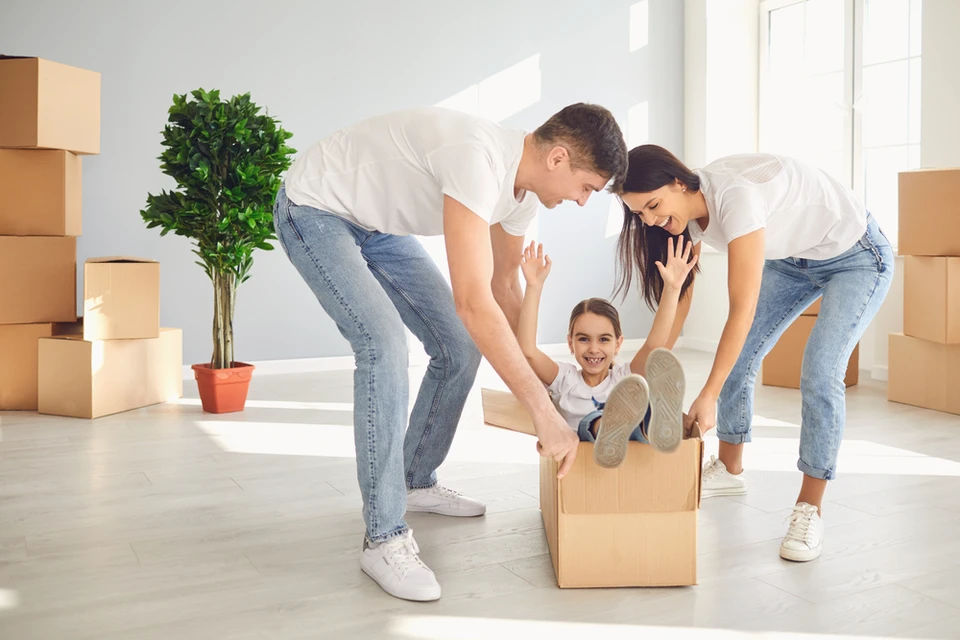 Famille dans salon lumineux avec cartons de déménagement
